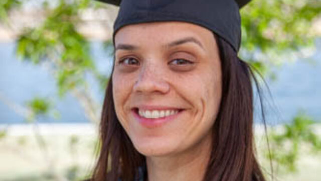 A person wearing a hat and smiling at the camera