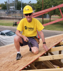 A man sitting on top of a wooden fence