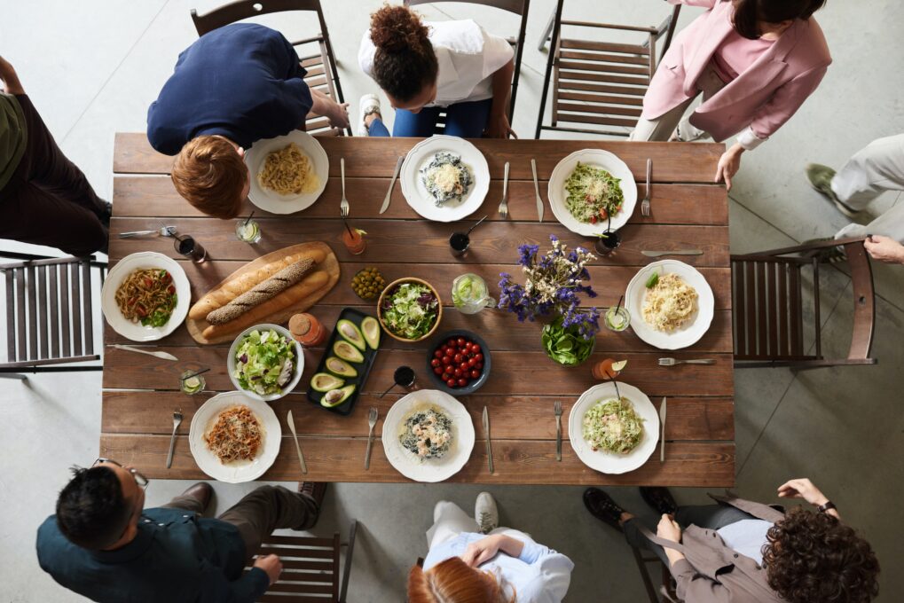 A group of people sitting at a table with plates of food