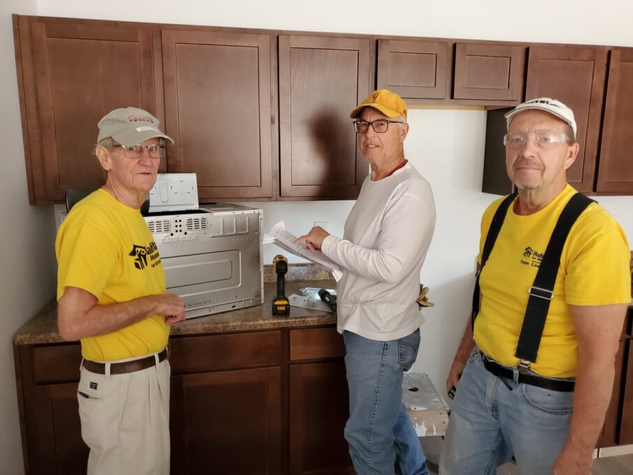A group of people standing in a kitchen