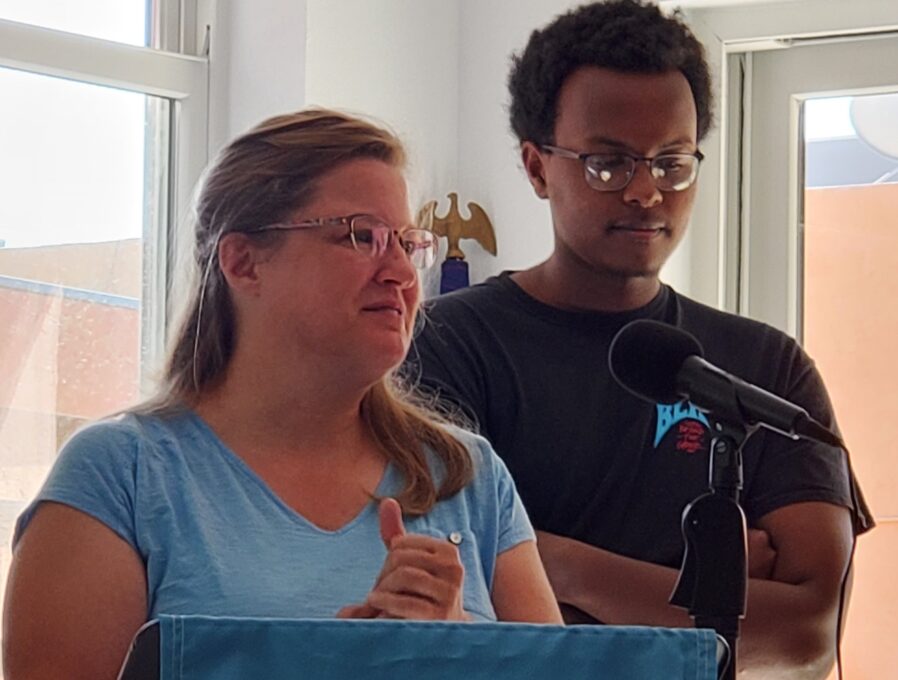 A man and a woman in glasses looking at the camera