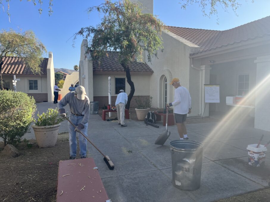 A group of people standing around a fire hydrant in front of a building