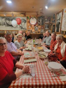 Grace Paley et al. sitting at a dinner table
