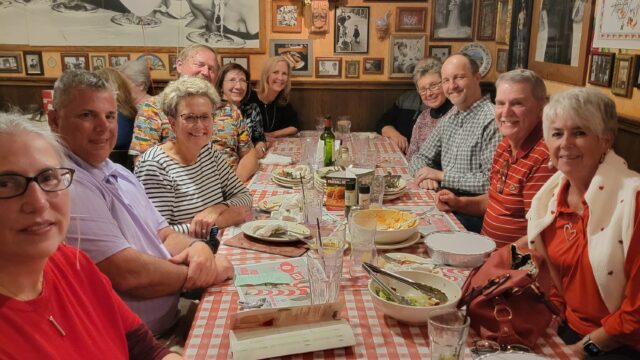 Grace Paley et al. sitting at a dinner table