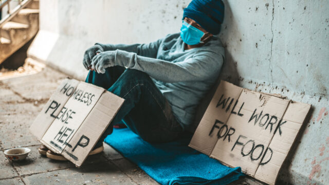 The beggars sat beside the street with a homeless message. Please help and work with food.