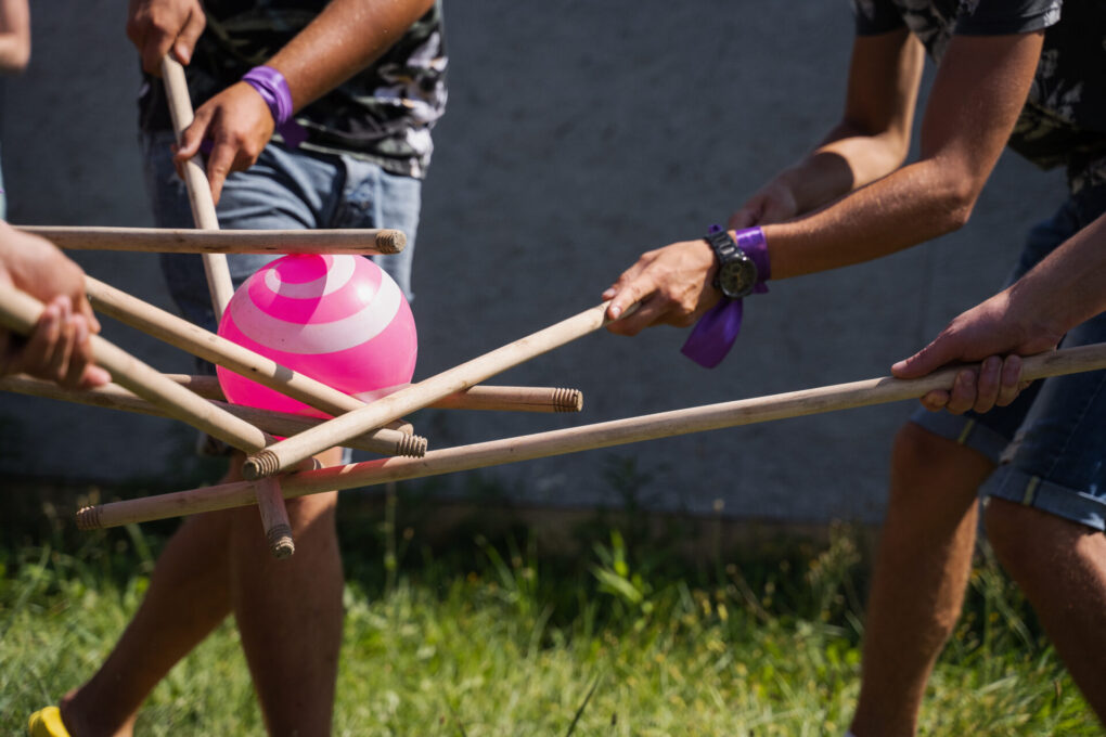 Teambuilding game for group of people for getting team spirit and increase friendship for colleagues. Team game with ball and sticks.