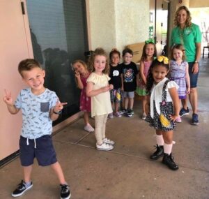 A small child is holding a bunch of little kids posing for a picture