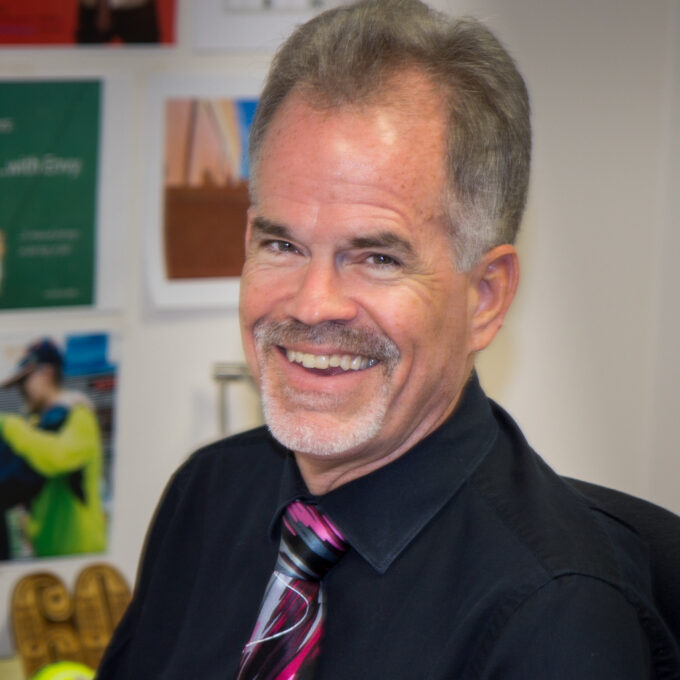 A man wearing a suit and tie smiling at the camera