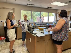 A group of people standing in a kitchen preparing food