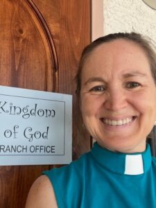 A smiling woman holding a sign posing for the camera