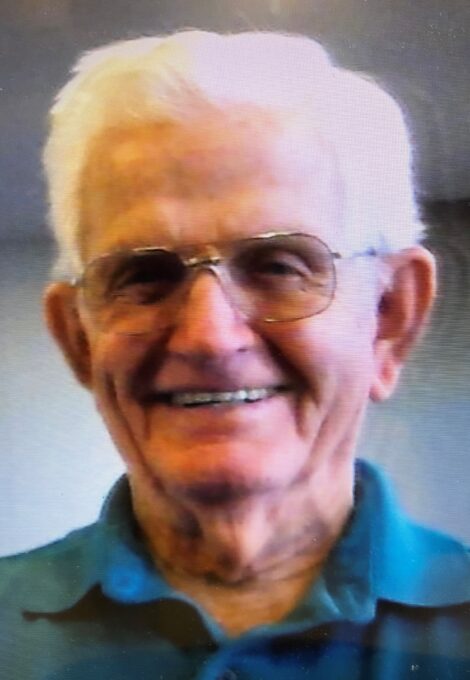 A close up of a man wearing glasses and smiling at the camera