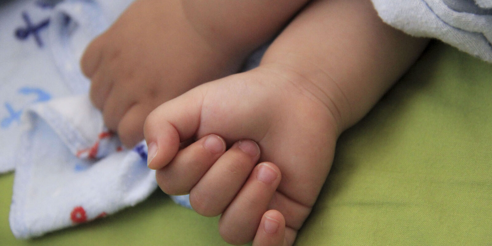 A hand holding a baby