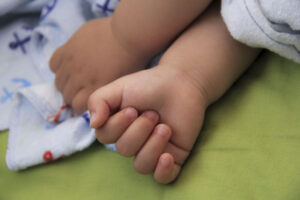 A hand holding a baby