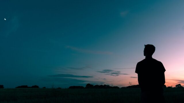 A man standing in front of a sunset