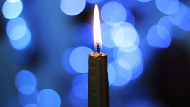 A candle against a blue background