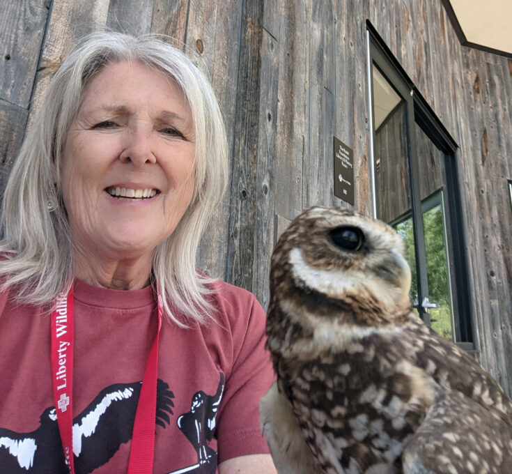 A woman standing in front of an owl