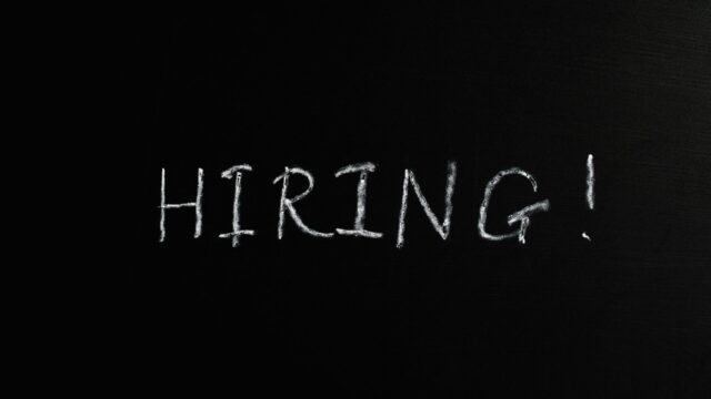 Close-up of the word 'Hiring!' written in white chalk on a blackboard, ideal for recruitment themes.