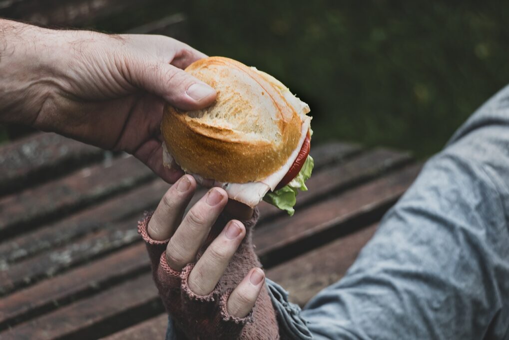 A close up of a person holding a sandwich in his hand