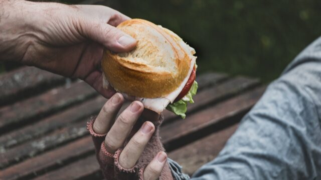 A close up of a person holding a sandwich in his hand