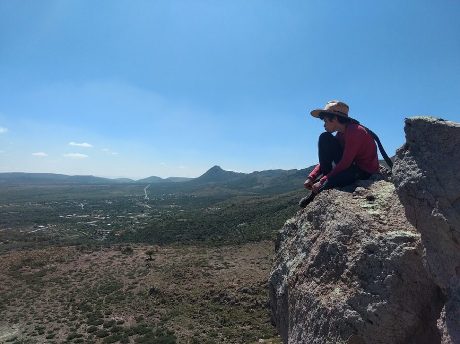 A man flying through the air on a rocky hill