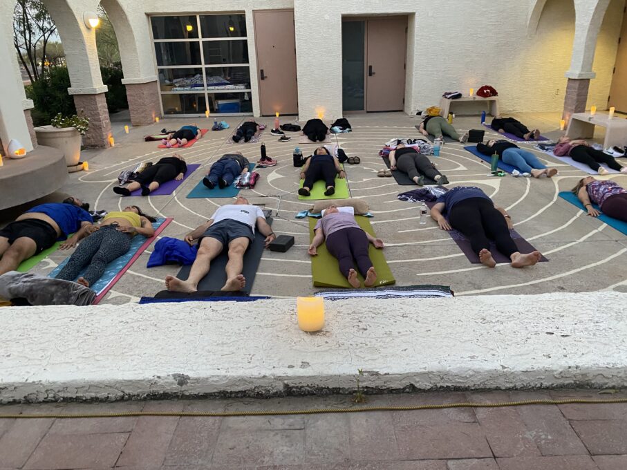 A group of people sitting on a sidewalk